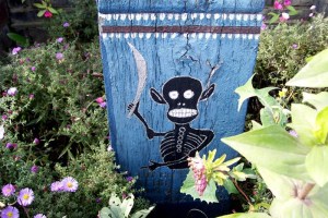 Grim Reaper Figure at Base of Tombstone